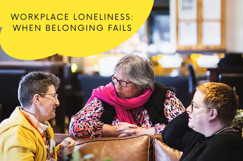 Three people in warm conversation, leaning in and connecting - illustrating belonging and human connection at work