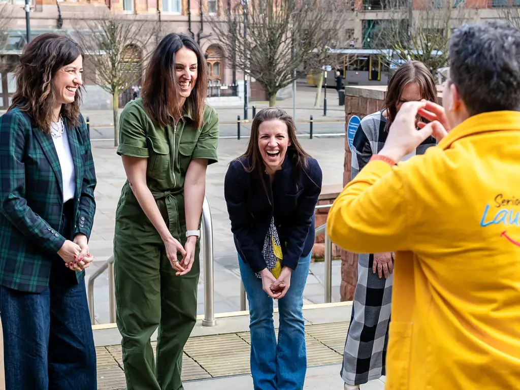 A group laughing together during a Serious Laughter session - illustrating how shared laughter rebuilds belonging and connection at work