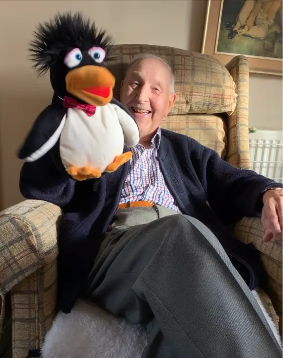 Elderly man laughing with puppet taking part in a Joyful Wellbeing Boost care home activities with Sunny Turner